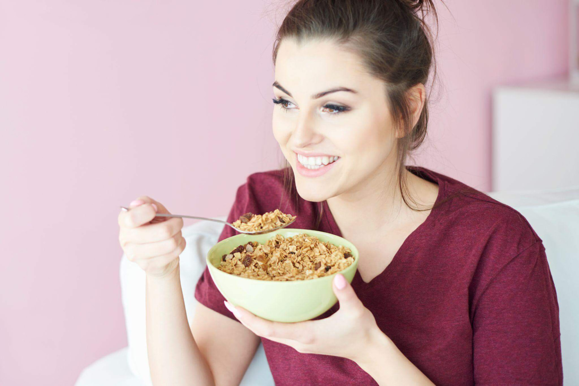 Young woman having a bowl of cereal with milk for breakfast